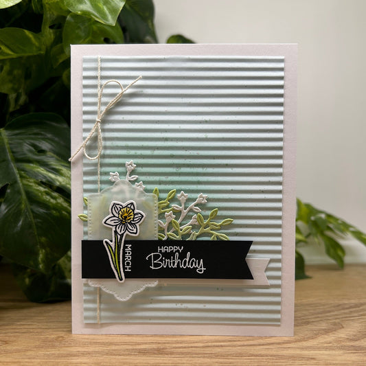 Handmade birthday card with floral design and 'Happy Birthday' text on a blue corrugated background.